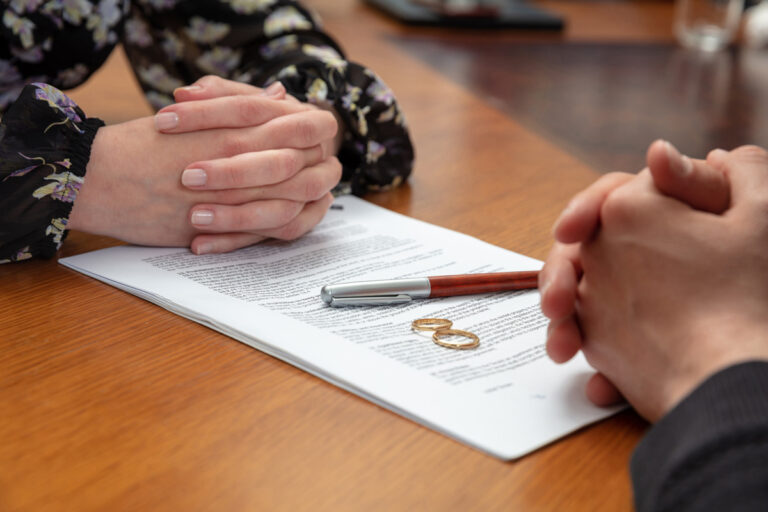 alimony-lawyer-winston-salem Two people’s hands on paperwork with wedding rings in Winston-Salem.