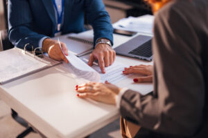 A business lawyer and a client reviewing paperwork at a desk in Winston-Salem.